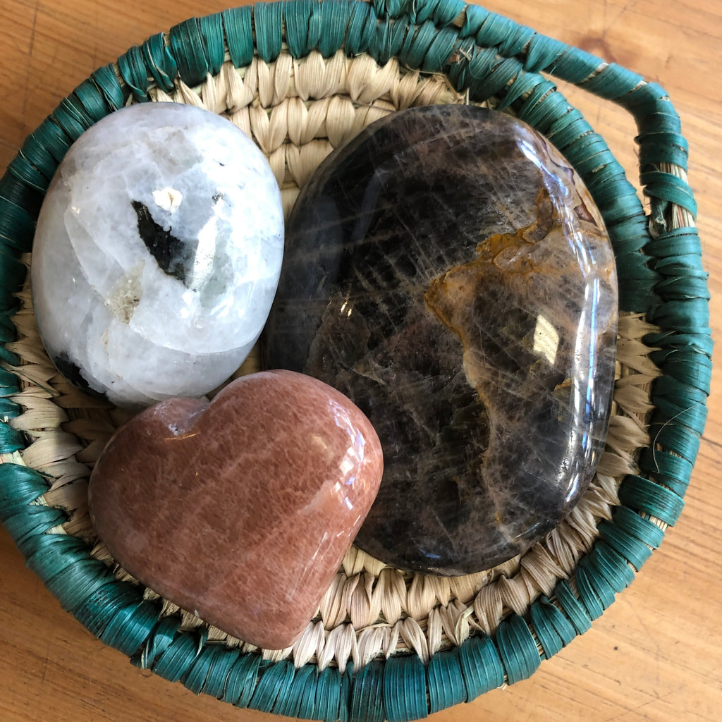 Three polioshed versions of Moonstone in a woven basket. 